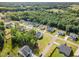 An aerial view of homes in a residential area featuring mature trees, well-maintained lawns, and winding streets at 220 W Amber Oak Dr, Selma, NC 27576