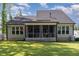 Spacious backyard featuring a screened-in porch, lush green lawn, and mature trees at 220 W Amber Oak Dr, Selma, NC 27576