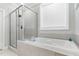 Elegant bathroom features a soaking tub with tile surround and a separate glass-enclosed shower at 220 W Amber Oak Dr, Selma, NC 27576