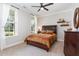 Cozy bedroom showcasing a dark wood bed frame, bright windows, and recessed lighting at 220 W Amber Oak Dr, Selma, NC 27576