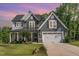 Charming two-story home featuring gray shingles, a manicured lawn, and a covered front porch at 220 W Amber Oak Dr, Selma, NC 27576