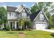 Charming two-story home featuring gray shingles, a manicured lawn, and a covered front porch at 220 W Amber Oak Dr, Selma, NC 27576