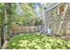Well-maintained backyard with stone house, new wooden fence, and green landscaping at 2203 University Dr, Durham, NC 27707