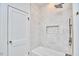 Modern bathroom featuring a bathtub, tiled walls, shower with black fixtures, and a door at 2203 University Dr, Durham, NC 27707