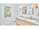 Bright bathroom featuring double vanity, marble countertops, and brushed gold fixtures at 2203 University Dr, Durham, NC 27707