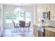 Bright dining room with modern light fixture, large windows, and updated stainless steel appliances at 2203 University Dr, Durham, NC 27707