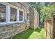 Detailed stone wall bordering the home with a view to the manicured green grass at 2203 University Dr, Durham, NC 27707