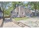 Stone exterior home featuring unique architectural details, with mature trees surrounding at 2203 University Dr, Durham, NC 27707