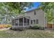 Lovely view of the backyard featuring a screened-in porch, green lawn, and mature trees for privacy at 3007 Shopton Dr, Apex, NC 27502