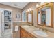 Neutral toned bathroom features a double sink vanity, wood framed mirrors, and adjacent walk-in closet at 3007 Shopton Dr, Apex, NC 27502