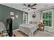 Cozy bedroom with a statement wall, two windows, a ceiling fan and soft, neutral decor at 3007 Shopton Dr, Apex, NC 27502