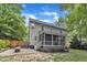 Exterior backyard view of home featuring a screened-in porch, stone patio, and lush green landscaping at 3007 Shopton Dr, Apex, NC 27502