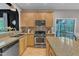 Kitchen with granite countertops, stainless appliances, wood cabinets, and a view to the porch at 3007 Shopton Dr, Apex, NC 27502