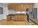 Kitchen with wood cabinets, granite countertops, stainless steel refrigerator and under cabinet lighting at 3007 Shopton Dr, Apex, NC 27502