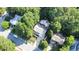 Aerial view showcasing the property surrounded by lush trees and a pool with outdoor living space at 302 Caraway Ln, Cary, NC 27519