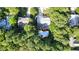 Aerial view showcasing the property surrounded by lush trees and a pool with outdoor living space at 302 Caraway Ln, Cary, NC 27519