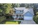 Aerial view of a charming two-story home with a two-car garage, light gray siding, and a lovely front porch at 302 Caraway Ln, Cary, NC 27519