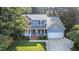 Charming two-story home with a welcoming front porch and a well-manicured lawn surrounded by mature trees at 302 Caraway Ln, Cary, NC 27519