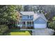 Charming two-story home with a welcoming front porch and a well-manicured lawn surrounded by mature trees at 302 Caraway Ln, Cary, NC 27519