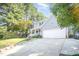 Inviting two-story home featuring a classic front porch, attached garage, and a sloped driveway amidst lush greenery at 302 Caraway Ln, Cary, NC 27519