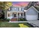 Charming two-story home with a two-car garage, light gray siding, and a lovely front porch at 302 Caraway Ln, Cary, NC 27519