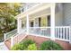 Close-up of a welcoming front porch with white columns, brick steps, and well-maintained landscaping details at 302 Caraway Ln, Cary, NC 27519