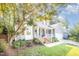 Inviting front porch with white railings, brick steps, and a cozy seating area, complemented by lush landscaping at 302 Caraway Ln, Cary, NC 27519