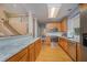 Open kitchen with modern appliances, wooden cabinetry, granite counters, and access to the staircase at 302 Caraway Ln, Cary, NC 27519