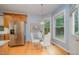 Cozy breakfast nook with a glass table, white chairs, and ample natural light from large windows at 302 Caraway Ln, Cary, NC 27519
