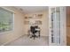 Bright home office with a window and a view, featuring a work table and shelving, viewed from french doors at 302 Caraway Ln, Cary, NC 27519
