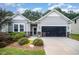 An exterior view of the house with a large, open garage, landscaping, and covered entry at 3037 Willow Ranch Dr, Fuquay Varina, NC 27526