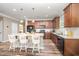 Charming kitchen featuring an island with bar stool seating, granite countertops, and wood-look flooring at 3037 Willow Ranch Dr, Fuquay Varina, NC 27526