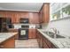 Well-lit kitchen featuring granite countertops, stainless steel appliances, and wood-look flooring at 3037 Willow Ranch Dr, Fuquay Varina, NC 27526