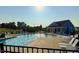 Exterior shot of the community pool featuring lounge chairs, umbrellas and a building for shade on a sunny day at 3037 Willow Ranch Dr, Fuquay Varina, NC 27526