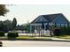 View of community pool with umbrellas, chairs and a building for shade, surrounded by a fence and grass at 3037 Willow Ranch Dr, Fuquay Varina, NC 27526