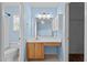 This full bathroom features a large mirror, vanity with storage, and blue accent paint at 304 Quailwood Dr, Fuquay Varina, NC 27526