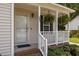 Welcoming front porch with hanging ferns, white railings and brick steps add cozy curb appeal at 304 Quailwood Dr, Fuquay Varina, NC 27526