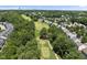 Aerial view featuring mature trees, residential buildings, and golf course in the background at 3207 Imperial Oaks Dr, Raleigh, NC 27614