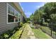 Landscaped backyard with stone pathway, green grass, flower garden, fence and trees at 3207 Imperial Oaks Dr, Raleigh, NC 27614