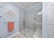 Shower featuring clear glass, marble tiling, shower head and bench in updated bathroom at 3207 Imperial Oaks Dr, Raleigh, NC 27614