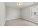 Bright, carpeted bedroom featuring a neutral color palette and a window allowing for plenty of natural light at 3401 Grosbeak Way, Raleigh, NC 27616
