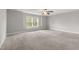 Spacious bedroom featuring a ceiling fan, neutral carpet, and a large window offering a bright and airy feel at 3401 Grosbeak Way, Raleigh, NC 27616