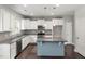 Modern kitchen featuring white cabinets, stainless steel appliances, granite countertops, and a center island at 3401 Grosbeak Way, Raleigh, NC 27616