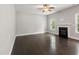Bright living room featuring dark wood flooring, a ceiling fan, fireplace, and many windows at 3401 Grosbeak Way, Raleigh, NC 27616