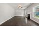 Open living room with a ceiling fan, modern fireplace, and large windows at 3401 Grosbeak Way, Raleigh, NC 27616