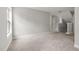 Open living room with neutral paint, carpet flooring, and staircase with an abundance of natural light streaming through the window at 3401 Grosbeak Way, Raleigh, NC 27616