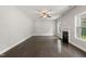 Bright living room featuring dark wood flooring, a ceiling fan, fireplace, and many windows at 3401 Grosbeak Way, Raleigh, NC 27616