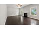 Living room with dark floors, ceiling fan, fireplace and plenty of light at 3401 Grosbeak Way, Raleigh, NC 27616