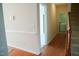 Hallway leading to laundry room with staircase on right and hardwood flooring at 3423 Van Hessen Dr, Raleigh, NC 27614