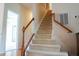 Carpeted staircase with wooden railing leads to the upper level of the home at 3423 Van Hessen Dr, Raleigh, NC 27614